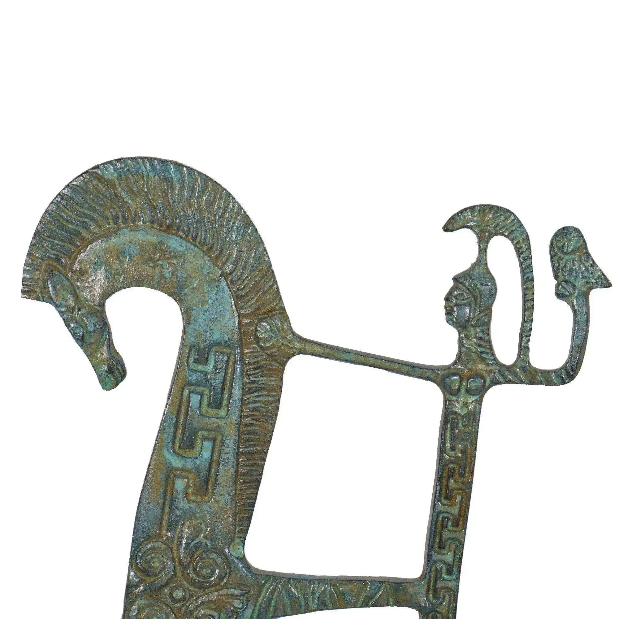 Close-up of the Greek bronze chariot with green patina, stylized horse, human figure, and geometric decorations on a white background.