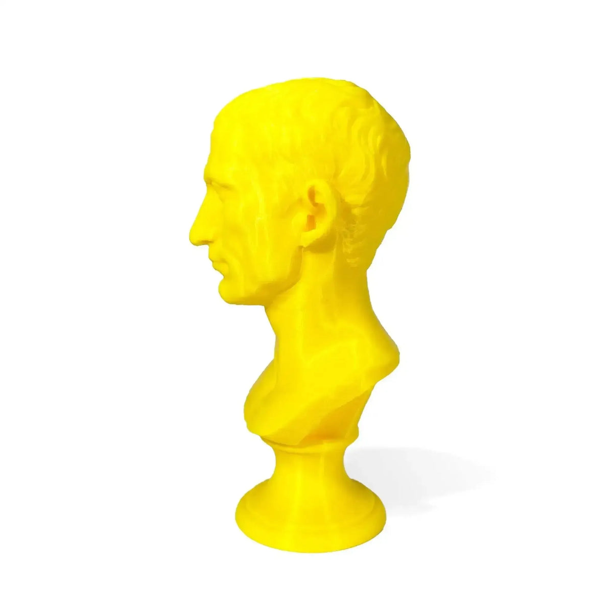 Busto di Giulio Cesare stampato in 3D giallo, vista di profilo su fondo bianco.