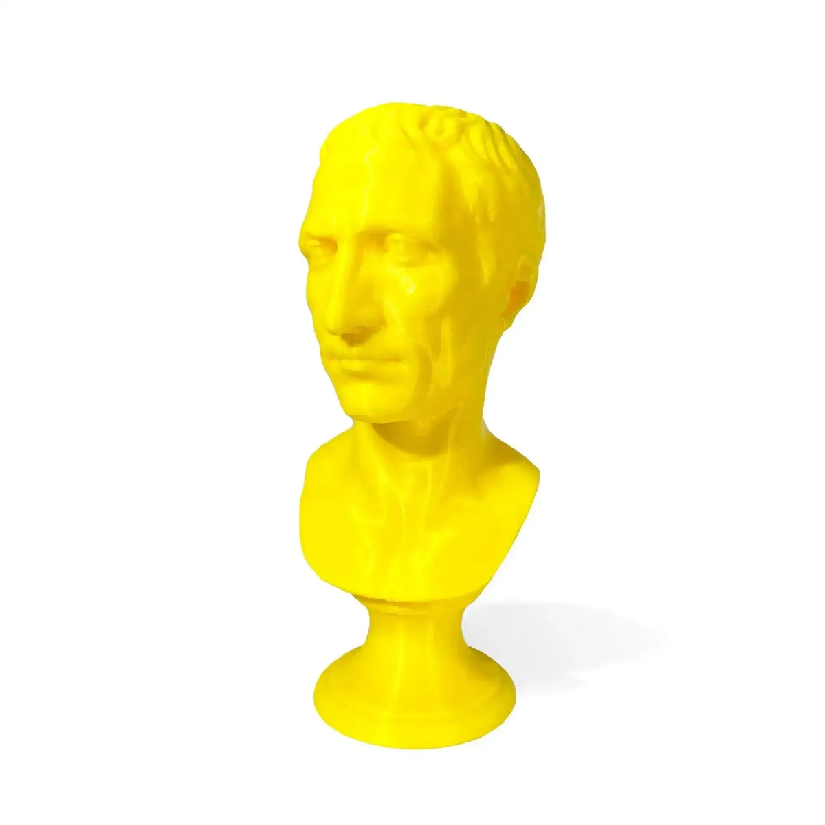 Busto di Giulio Cesare stampato in 3D giallo, vista di tre quarti su fondo bianco.
