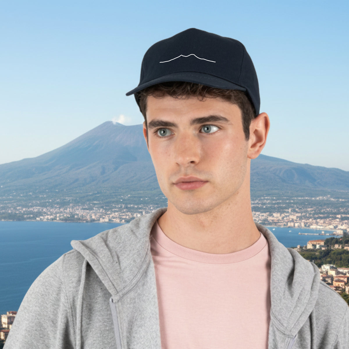 Model wearing a blue hat with Vesuvio embroidery, front view.