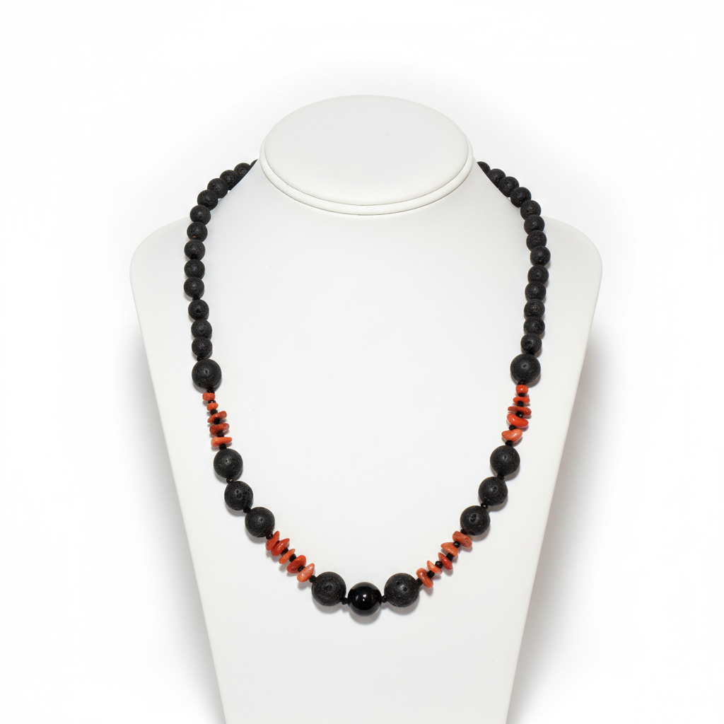 Collana in pietra lavica, onice e corallo rosso su un espositore bianco