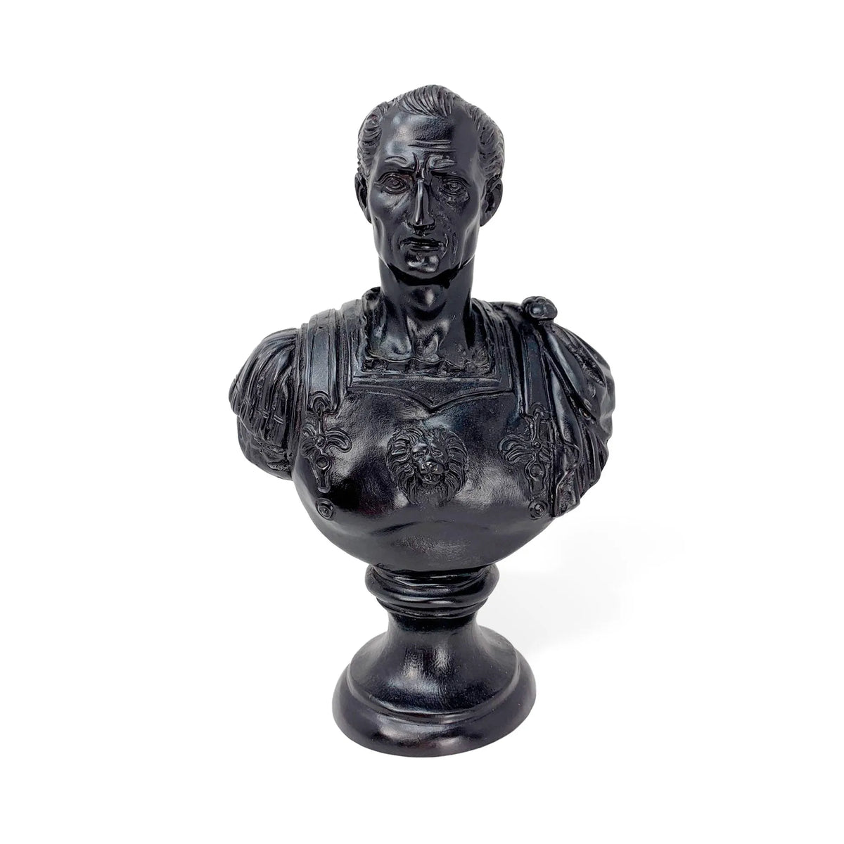 Busto di Giulio Cesare in bronzo con patina nera e corazza decorata, vista frontale su fondo bianco.