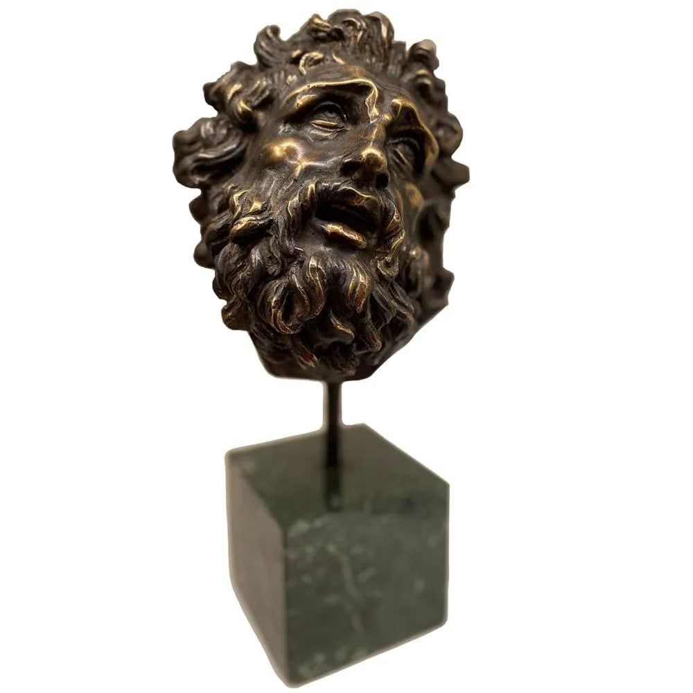 Testa del Laocoonte in bronzo su base in marmo verde, fotografata di tre quarti con barba scolpita, capelli ricci e dettagli espressivi del volto.