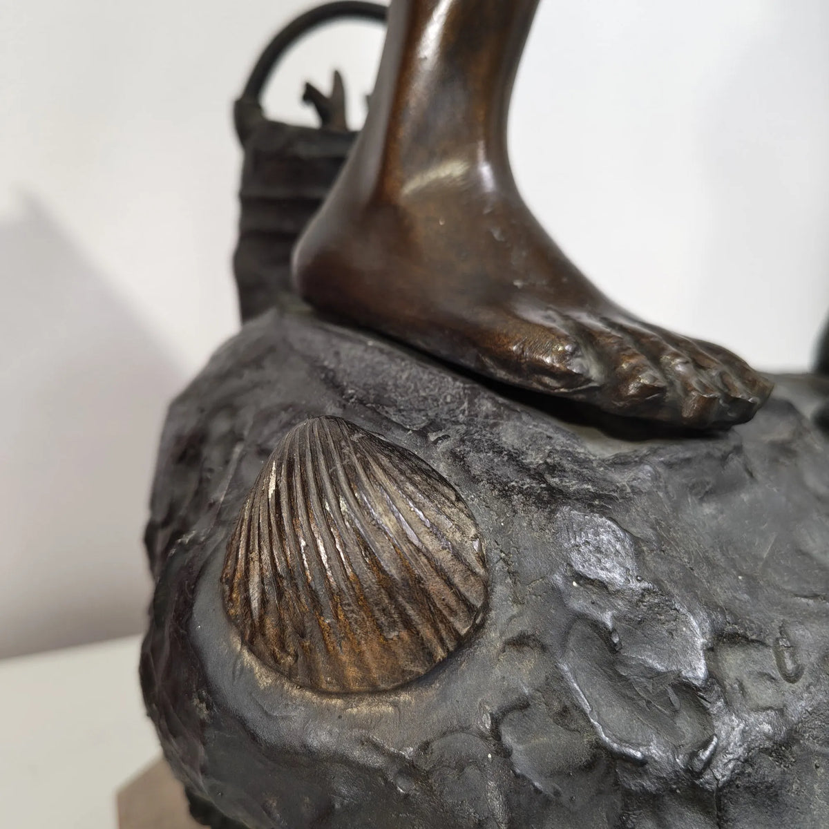 Dettaglio della base della scultura del Pescatorello in bronzo