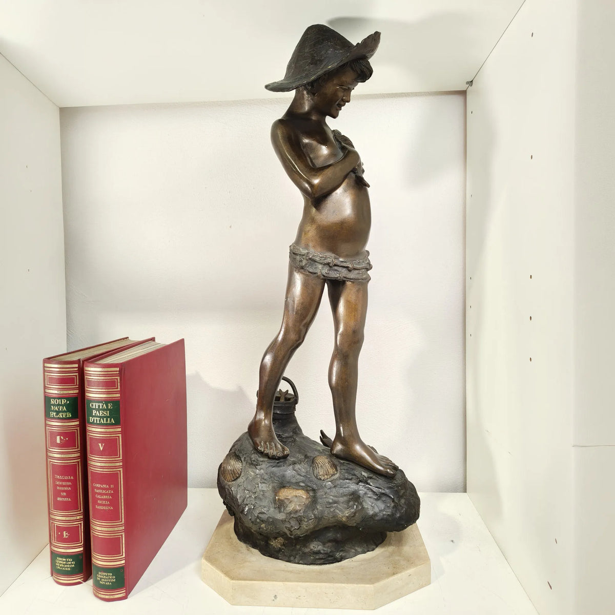 Dettaglio delle mani del giovane pescatore in bronzo
