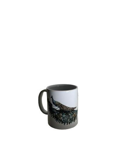 Tazza bianca con pavone e decorazione vegetale, su fondo bianco