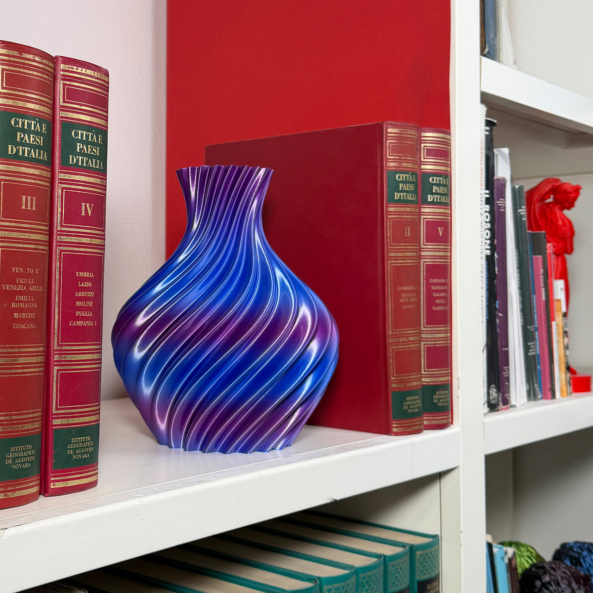 Blue/purple vase on shelf with books