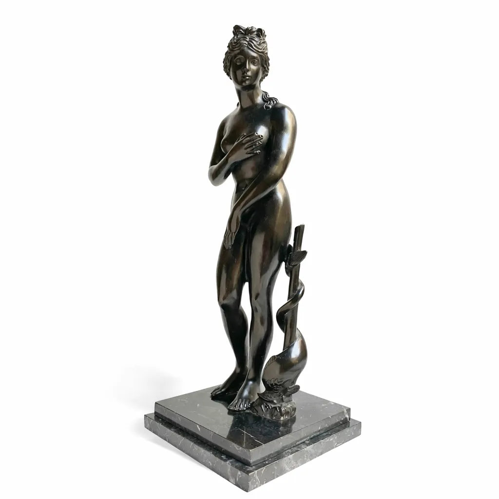 Venere dei Medici in bronzo scuro, vista a tre quarti con delfino accanto alla gamba, su fondo bianco.
