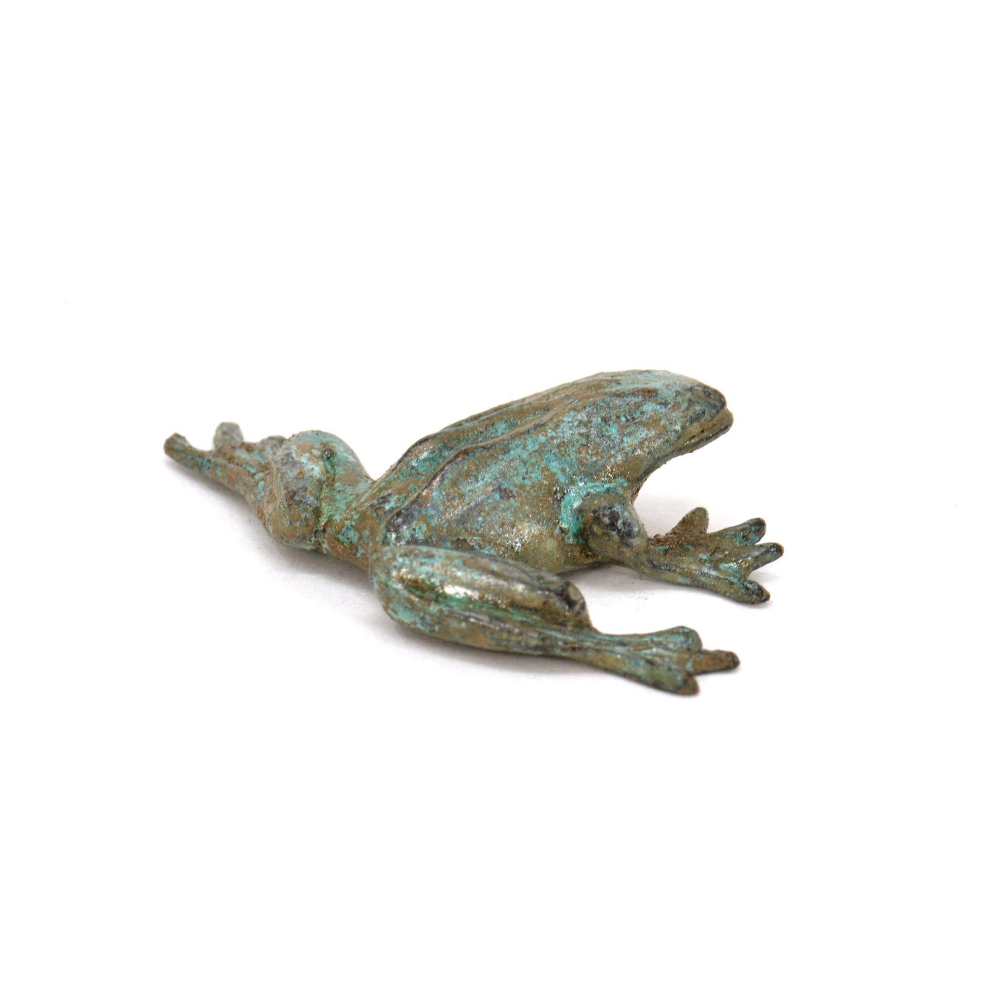 Petite grenouille décorative en bronze avec surface oxydée vert-bleu, photographiée de côté sur fond blanc.