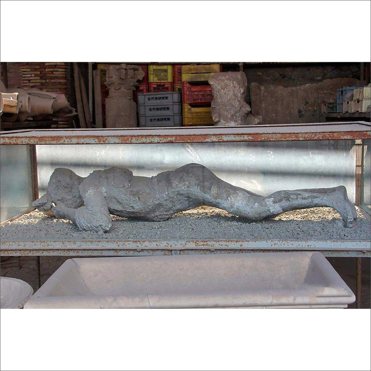Calco pompeiano di una figura distesa con le mani vicino al volto, esposto in una vetrina.