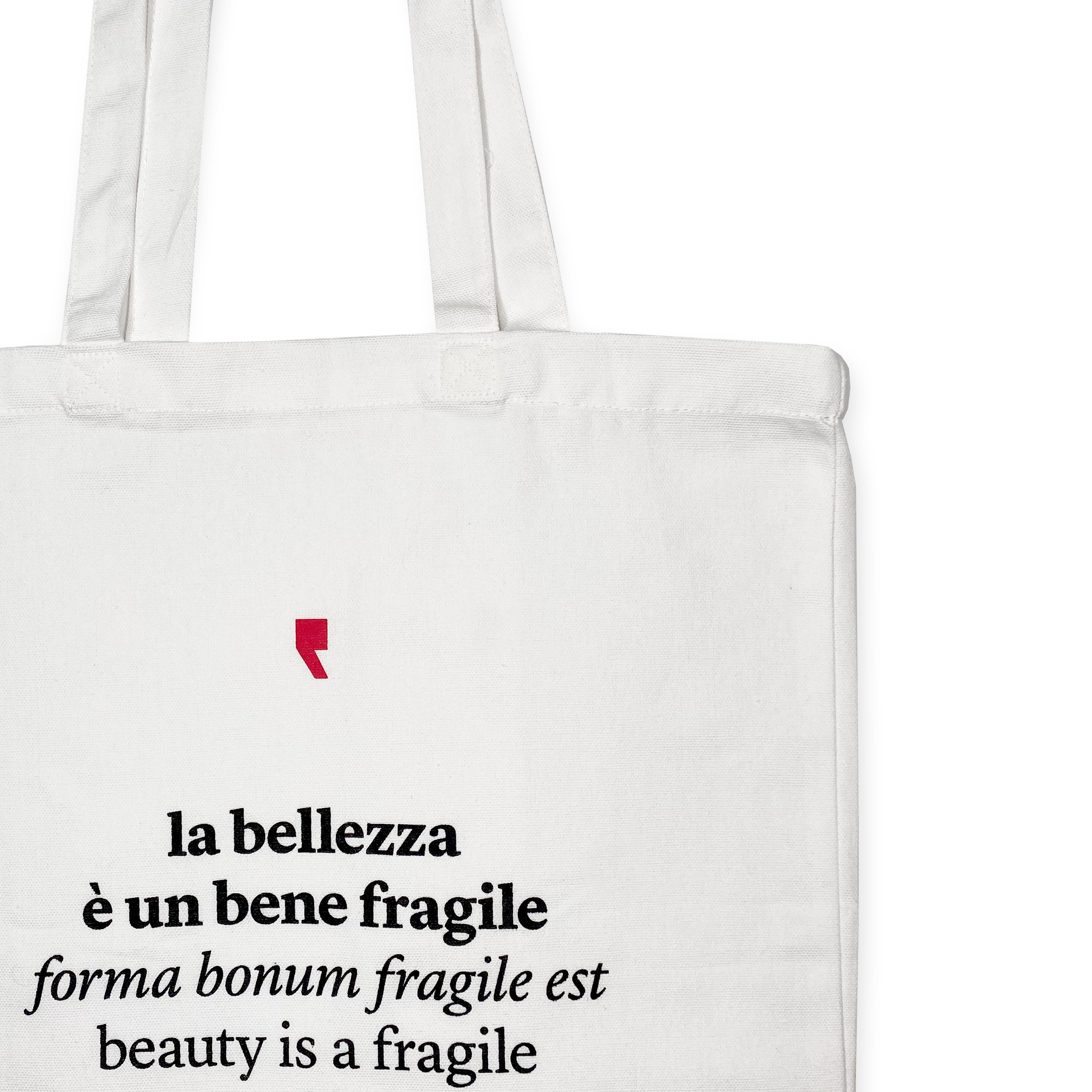 Detail of the phrase "Beauty is a fragile good" printed in black on white cotton shopper – poetic quote by Ovid